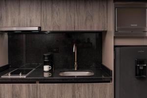 a kitchen with a sink and a coffee maker at Amari Living Suites in Barranquilla