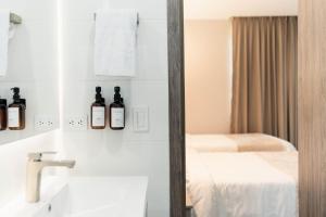 a bathroom with two bottles of wine on the wall at Amari Living Suites in Barranquilla