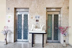Habitación con 2 puertas de cristal y jarrones con flores en Collection O Hotel Mapple by green leaves, en Pune