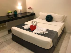 Dos camas en una habitación de hotel con un corazón en ellas en The Platinum KLCC by Moonlight en Kuala Lumpur
