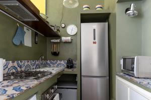 Il comprend une cuisine équipée d'un réfrigérateur et d'un comptoir. dans l'établissement Colosseo Apartment- Heart of Rione Monti, à Rome