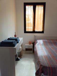 a bedroom with a bed and a desk and a window at A Casa di Amici in Arezzo