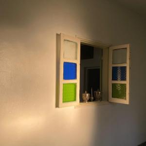 a window with three different colored windows in a room at Green IGR Guesthouse in Agadir