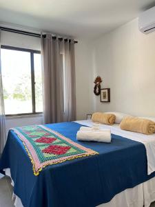 a bedroom with a bed with a blue blanket on it at Pousada do lago in Guaramiranga