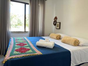 a bedroom with a bed with two towels on it at Pousada do lago in Guaramiranga