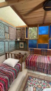 a room with two beds and a table and windows at Nassimah in Giza