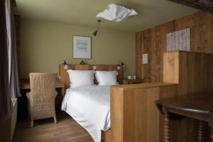 een slaapkamer met een bed en een tafel met een stoel bij Poëziehotel Surplace in Bever
