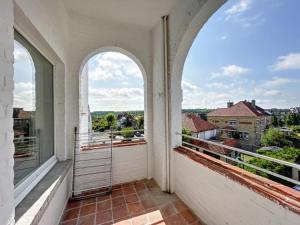 a balcony with two arched windows and a view at Loft Monaco - Ruime vakantieloft in De Panne