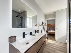 a bathroom with a sink and a mirror at Loft Monaco - Ruime vakantieloft in De Panne