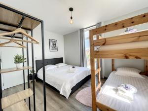 a bedroom with two bunk beds and a window at Loft Monaco - Ruime vakantieloft in De Panne