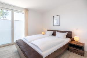 a bedroom with a large bed and a large window at Apartment "Haffliebe" - Haffresidenz in Garz