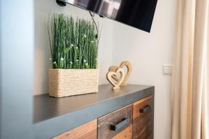 a cabinet with a heart decoration and a plant at Apartment "Haffliebe" - Haffresidenz in Garz +25 photos