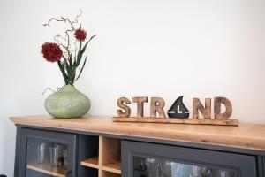 a vase sitting on top of a wooden table with a sign at Apartment "Haffliebe" - Haffresidenz in Garz