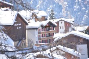 a group of buildings are covered in snow at Hotel Edelbock in Grächen