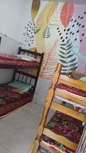 um quarto com 2 beliches e um mural em Pousada Aconchego em São Luís