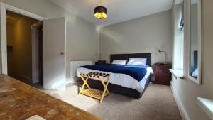 a bedroom with a bed with a blue comforter at Comfy home very close to Cardiff in Barry