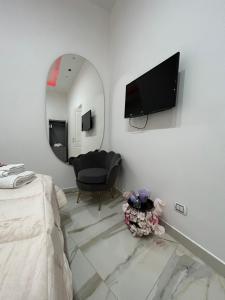 een slaapkamer met een bed, een spiegel en een stoel bij Marghe Luxury Home in Napels
