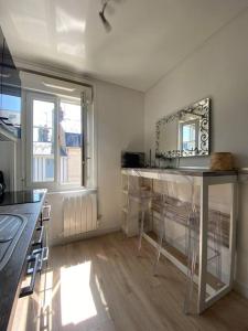 una cucina con bancone e sedie in camera di Studio avec terrasse à Deauville a Deauville