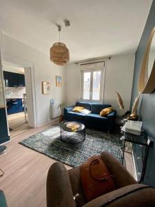sala de estar con sofá azul y mesa en Studio avec terrasse à Deauville en Deauville