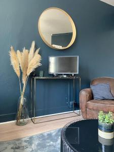 un soggiorno con specchio e TV di Studio avec terrasse à Deauville a Deauville