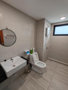 a bathroom with a sink and a toilet and a mirror at Cozy 2room 6pax @ Menara Sentral in Bukit Mertajam