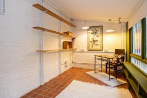 曼徹斯特的住宿－GuestReady - Elegant home in Manchester，一间设有桌子和白色砖墙的房间