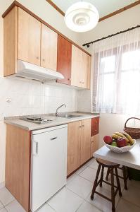 a kitchen with a sink and a bowl of fruit on a table at Sofia's Studios in Asos