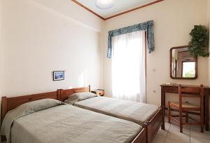 a bedroom with two beds and a mirror and a chair at Sofia's Studios in Asos