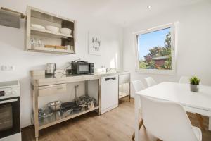 une cuisine avec une table et un comptoir blanc dans l'établissement Stilvoller Bungalow in Selm-Cappenberg, à Selm 11 autres photos