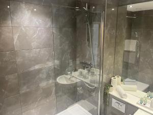 a bathroom with a shower and a sink at The Axium Superior Apartment in Birmingham