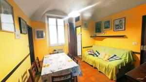 gelbes Zimmer mit einem Bett und einem Tisch in der Unterkunft La Bandinella in Albissola Marina