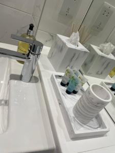 a white refrigerator with a stack of plates and cups at The Axium Superior Apartment in Birmingham