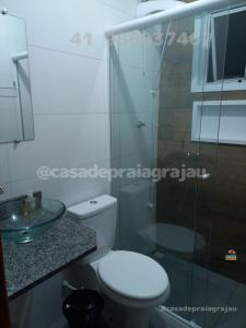 ein Badezimmer mit Toilette und Glasdusche in der Unterkunft @casadepraiagrajau in Pontal do Paraná