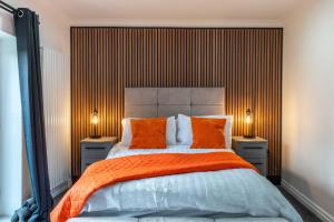 a bedroom with a large bed with orange pillows at 2 The Cottage in Upholland