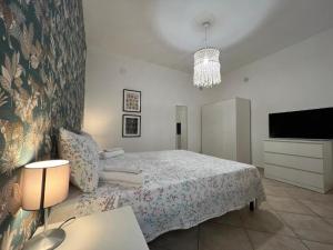 ein weißes Schlafzimmer mit Bett und Fernseher in der Unterkunft Pardus Domus HOWME in Bari
