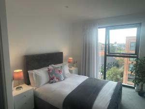 1 dormitorio con cama y ventana grande en The Axium Superior Apartment en Birmingham