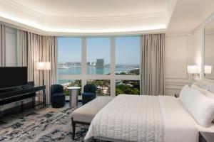 Le Meridien Mina Seyahi Beach Resort & Waterpark في دبي: غرفة فندقية بسرير ونافذة كبيرة