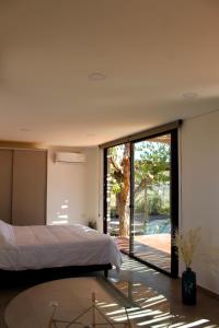 a bedroom with a bed and a sliding glass door at Lodwine Lodge Apartments in Ciudad Lujan de Cuyo