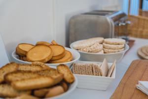 a table with three bowls of bread and snacks at Hotel The Originals Château de Perigny in Vouillé