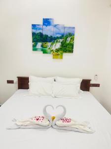 Una cama blanca con dos toallas en forma de corazón. en Akeinya villa en Galle