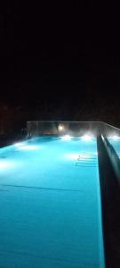 uma piscina de água azul à noite com luzes em Longroiva Hotel Rural em Longroiva