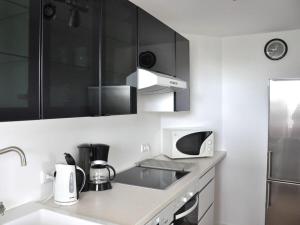 a kitchen with black and white cabinets and a sink at Ferienwohnung-Strandpfoetchen in Avendorf auf Fehmarn