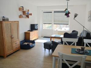 a living room with a table and chairs and a television at Ferienwohnung-Strandpfoetchen in Avendorf auf Fehmarn