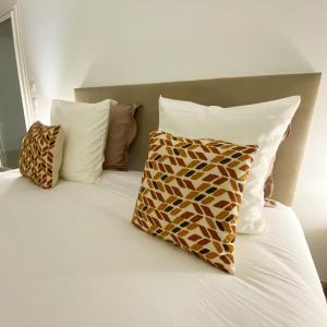 a bed with two pillows and a white bedsheet at Baya Spa in Les-Pennes-Mirabeau