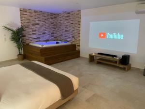 a bedroom with a bed and a projection screen at Baya Spa in Les-Pennes-Mirabeau