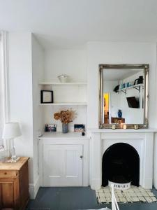 een woonkamer met een spiegel en een open haard bij Pretty studio, 2 minutes to beach! Self-contained. in Brighton & Hove