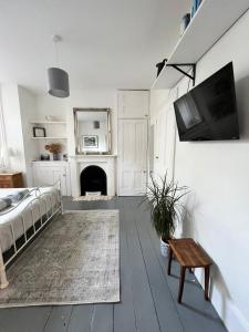een woonkamer met een bed en een tv aan de muur bij Pretty studio, 2 minutes to beach! Self-contained. in Brighton & Hove