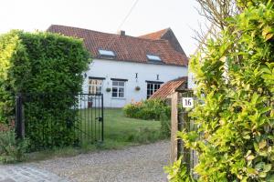 una casa blanca con una puerta delante de ella en La Bergerie, en Leuze-en-Hainaut