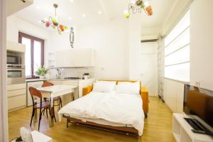 a bedroom with a bed and a table and a kitchen at Bilocale Bocconi - silenzioso - piano alto in Milan
