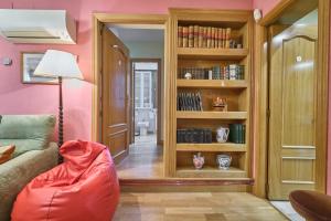 sala de estar con sofá y estante para libros en Apartamentos Carlos, en Madrid